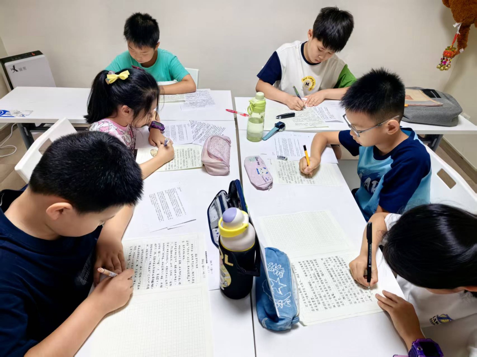 孩子们低头围桌进行写作练习